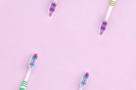 A lot of toothbrushes lie on a pastel pink background. Top view, flat lay. Minimal concept.の写真素材