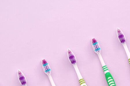 A lot of toothbrushes lie on a pastel pink background. Top view, flat lay. Minimal concept.の写真素材