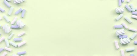 Colorful marshmallow laid out on lime paper background. pastel creative textured framework. minimal.