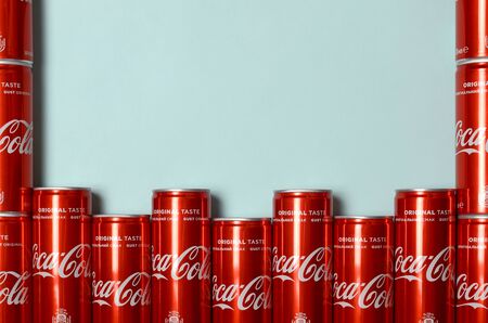 KHARKIV, UKRAINE - JULY 15, 2019: Flat lay shot carbonated red drink tin cans Coca Cola laying on...