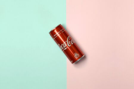 KHARKIV, UKRAINE - JULY 15, 2019: Flat lay shot single red drink tin can Coca Cola laying on pastel...