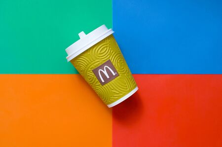 KHARKIV, UKRAINE - AUGUST 1, 2019: McDonald's paper disposable coffee cup on bright colors mix...