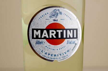 KHARKOV, UKRAINE - SEPTEMBER 23, 2019: Bottle of Vermouth Martini Rossi close up logo on beige wall...