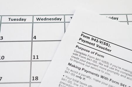 IRS Form 941-V Payment Voucher blank lies on empty calendar page. Tax period concept. Copy space for...
