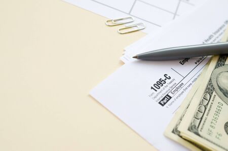 IRS Form 1095-C Employer-Provided Health Insurance Offer and Coverage tax blank lies with pen and...