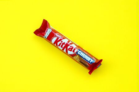 KHARKOV, UKRAINE - OCTOBER 17, 2019: Kit Kat chocolate bar in red wrapping lies on bright yellow...