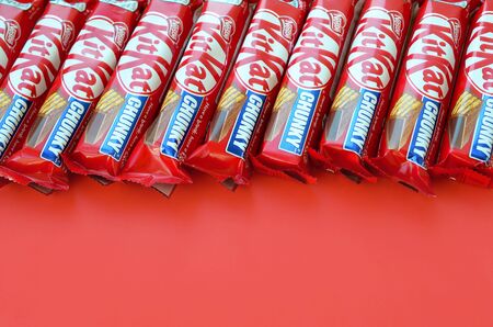 KHARKOV, UKRAINE - OCTOBER 17, 2019: Kit Kat chocolate bars in red wrapping lies on yellow...
