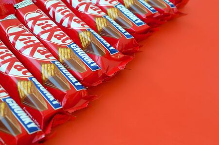 KHARKOV, UKRAINE - OCTOBER 17, 2019: Kit Kat chocolate bars in red wrapping lies on yellow...