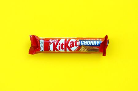 KHARKOV, UKRAINE - OCTOBER 17, 2019: Kit Kat chocolate bar in red wrapping lies on bright yellow...