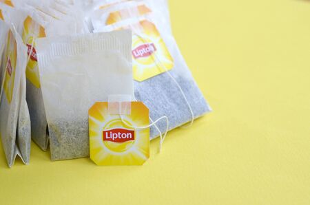 KHARKOV, UKRAINE - OCTOBER 4, 2019: Lipton Yellow Label black tea bags on pastel yellow surface close up. Lipton is a world famous brand of teaのeditorial素材