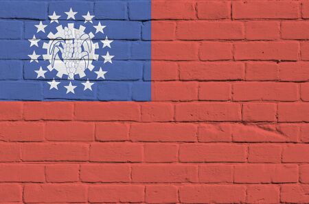 Myanmar flag depicted in paint colors on old brick wall close up. Textured banner on big brick wall masonry backgroundの写真素材