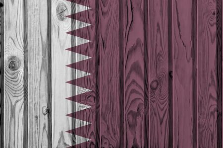 Qatar flag depicted in bright paint colors on old wooden wall close up. Textured banner on rough backgroundの写真素材