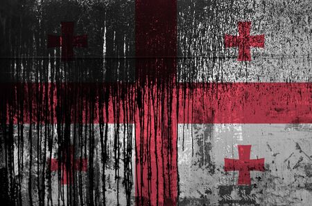 Georgia flag depicted in paint colors on old and dirty oil barrel wall close up. Textured banner on rough backgroundの写真素材