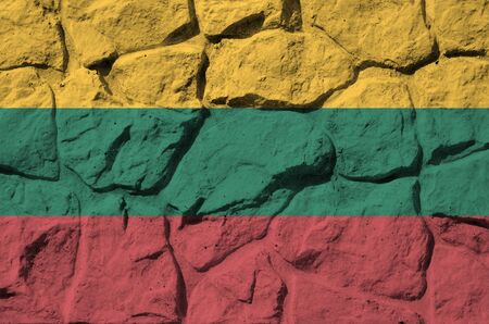 Lithuania flag depicted in paint colors on old stone wall close up. Textured banner on rock wall backgroundの写真素材