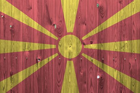 Macedonia flag depicted in bright paint colors on old wooden wall close up. Textured banner on rough backgroundの写真素材