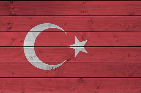 Turkey flag depicted in bright paint colors on old wooden wall close up. Textured banner on rough...