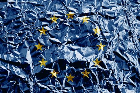 European union flag depicted in paint colors on shiny crumpled aluminium foil close up. Textured...