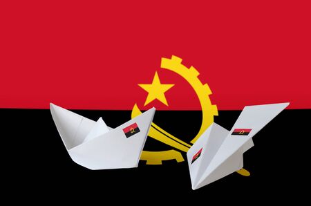 Angola flag depicted on paper origami airplane and boat. Oriental handmade arts conceptの写真素材