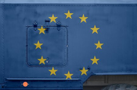 European union flag depicted on side part of military armored truck close up. Army forces vehicle...