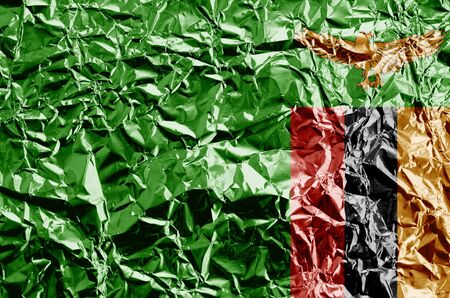 Zambia flag depicted in paint colors on shiny crumpled aluminium foil close up. Textured banner on rough backgroundの写真素材