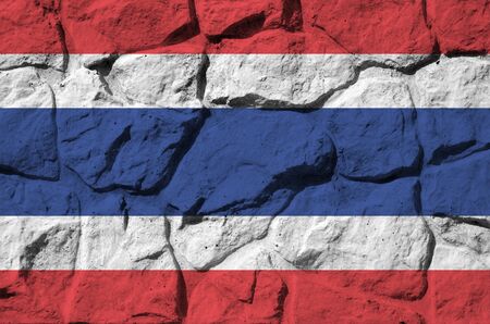 Thailand flag depicted in paint colors on old stone wall close up. Textured banner on rock wall backgroundの写真素材