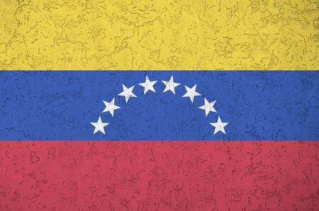 Venezuela flag depicted in bright paint colors on old relief plastering wall close up. Textured banner on rough backgroundの写真素材