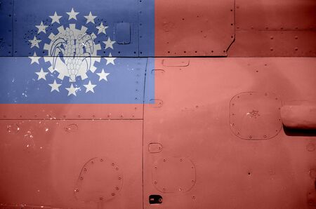 Myanmar flag depicted on side part of military armored helicopter close up. Army forces aircraft...