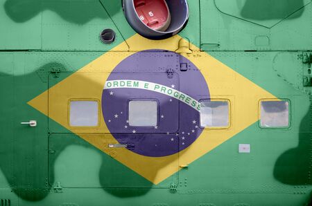 Brazil flag depicted on side part of military armored helicopter close up. Army forces aircraft...