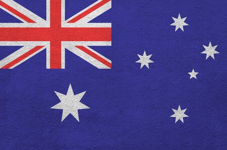 Australia flag depicted in bright paint colors on old relief plastering wall close up. Textured banner on rough backgroundの写真素材