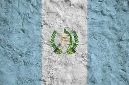 Guatemala flag depicted in bright paint colors on old relief plastering wall close up. Textured banner on rough backgroundの写真素材