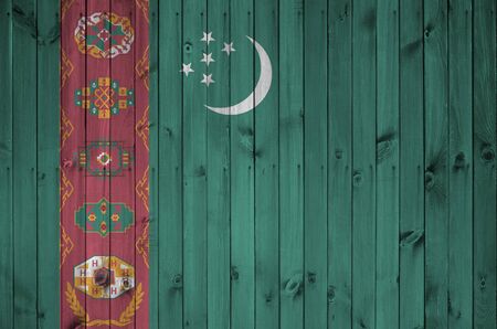 Turkmenistan flag depicted in bright paint colors on old wooden wall close up. Textured banner on rough backgroundの写真素材