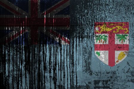 Fiji flag depicted in paint colors on old and dirty oil barrel wall close up. Textured banner on rough backgroundの写真素材