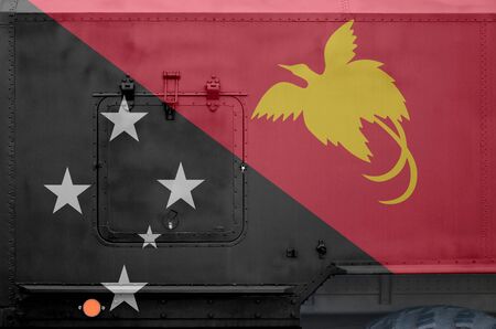 Papua New Guinea flag depicted on side part of military armored truck close up. Army forces vehicle...