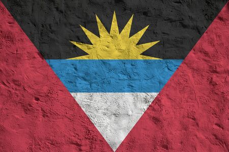 Antigua and Barbuda flag depicted in bright paint colors on old relief plastering wall close up. Textured banner on rough backgroundの写真素材