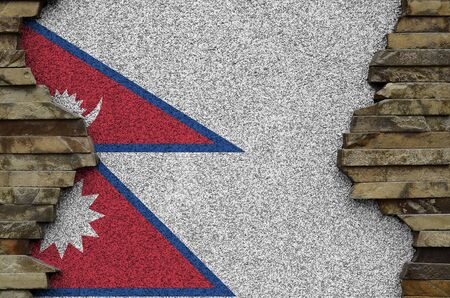 Nepal flag depicted in paint colors on old stone wall close up. Textured banner on rock wall backgroundの写真素材