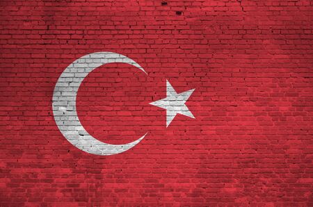 Turkey flag depicted in paint colors on old brick wall close up. Textured banner on big brick wall masonry backgroundの写真素材
