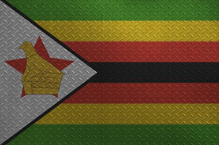 Zimbabwe flag depicted in paint colors on old brushed metal plate or wall close up. Textured banner on rough backgroundの写真素材