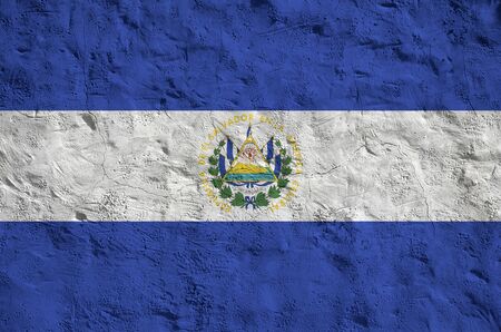 El Salvador flag depicted in bright paint colors on old relief plastering wall close up. Textured banner on rough backgroundの写真素材