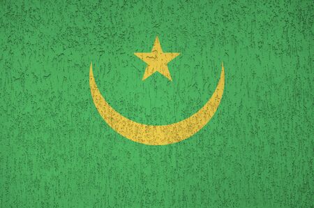 Mauritania flag depicted in bright paint colors on old relief plastering wall close up. Textured banner on rough backgroundの写真素材