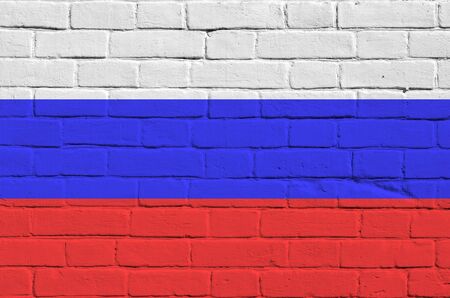 Russia flag depicted in paint colors on old brick wall close up. Textured banner on big brick wall...