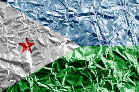 Djibouti flag depicted in paint colors on shiny crumpled aluminium foil close up. Textured banner on rough backgroundの写真素材