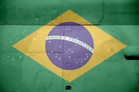 Brazil flag depicted on side part of military armored helicopter close up. Army forces aircraft...