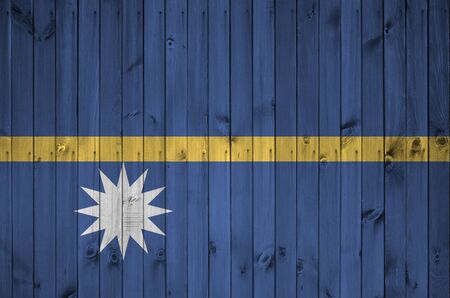 Nauru flag depicted in bright paint colors on old wooden wall close up. Textured banner on rough backgroundの写真素材