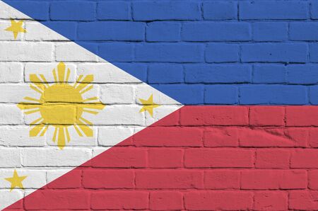 Philippines flag depicted in paint colors on old brick wall close up. Textured banner on big brick wall masonry backgroundの写真素材