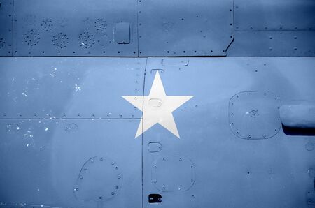 Somalia flag depicted on side part of military armored helicopter close up. Army forces aircraft...