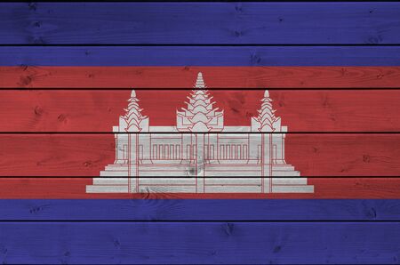 Cambodia flag depicted in bright paint colors on old wooden wall close up. Textured banner on rough backgroundの写真素材