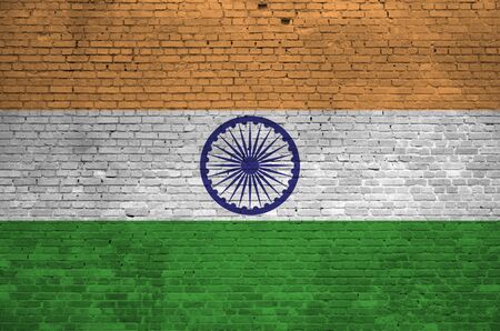 India flag depicted in paint colors on old brick wall close up. Textured banner on big brick wall masonry backgroundの写真素材