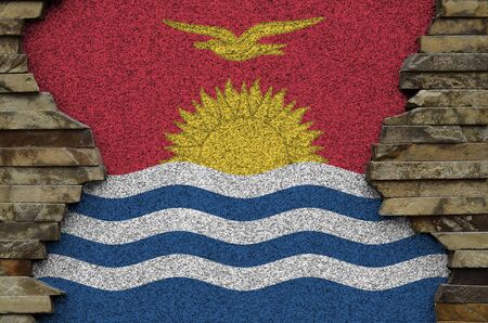 Kiribati flag depicted in paint colors on old stone wall close up. Textured banner on rock wall backgroundの写真素材