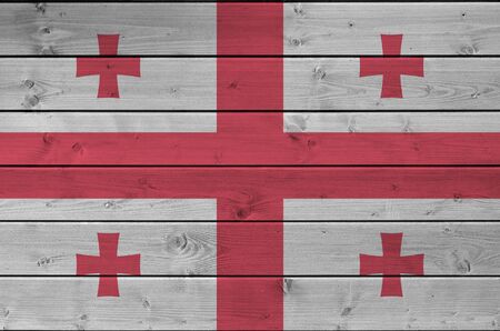 Georgia flag depicted in bright paint colors on old wooden wall close up. Textured banner on rough backgroundの写真素材