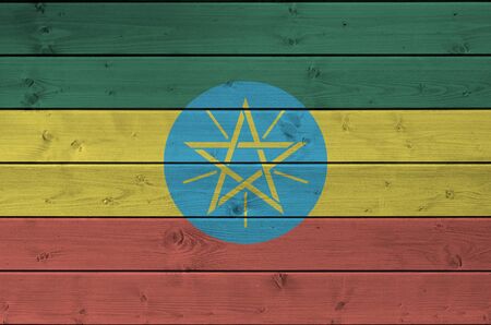 Ethiopia flag depicted in bright paint colors on old wooden wall close up. Textured banner on rough backgroundの写真素材